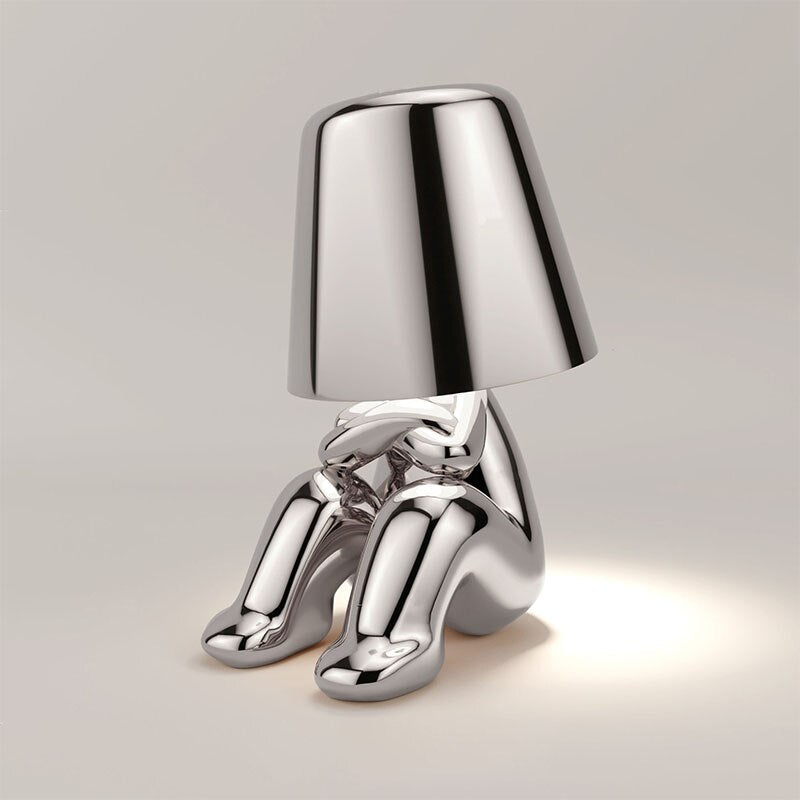 Metallic table light with reflective artistic form