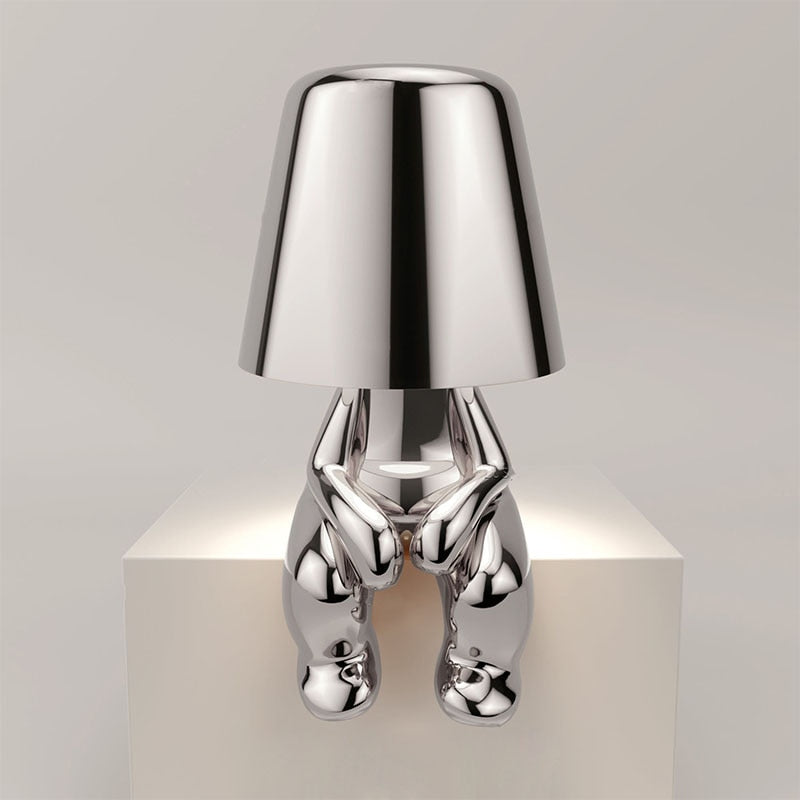 Metallic table light with reflective artistic form